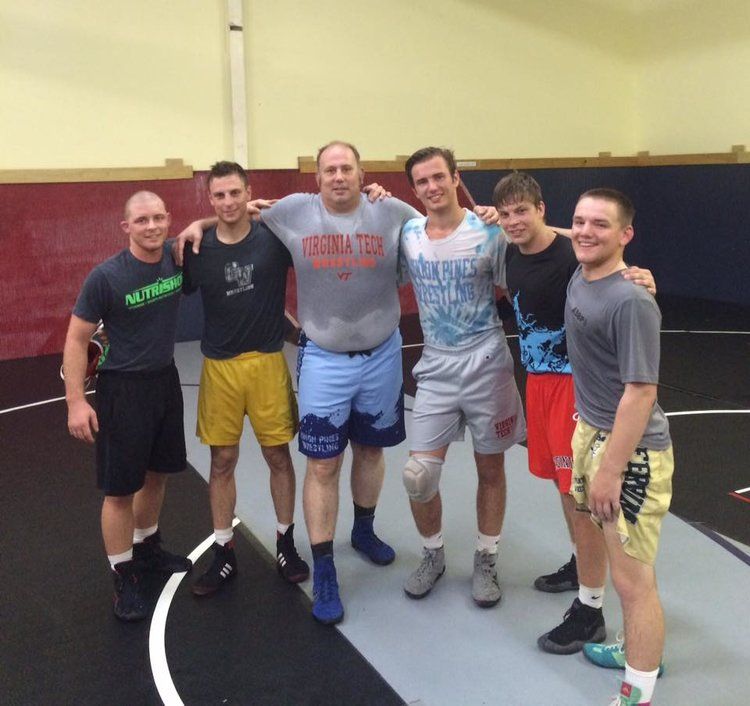 Group of wrestlers posing on mat